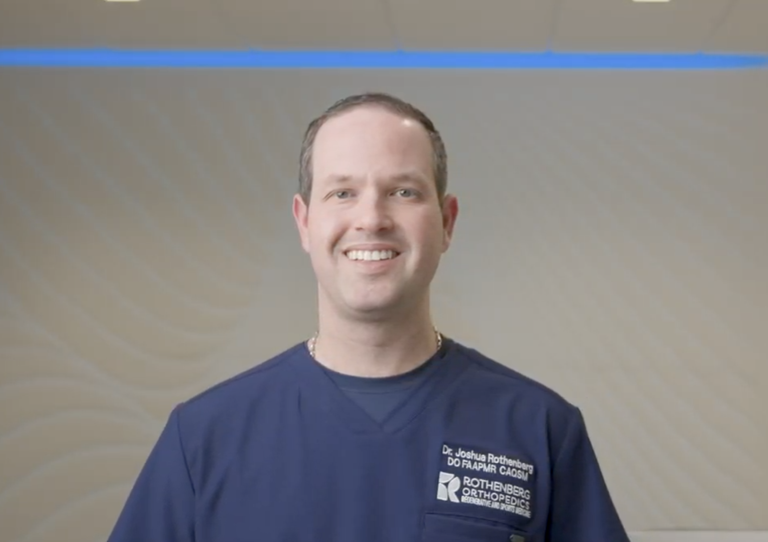 Dr. Rothenberg smiling at the camera in office scrubs